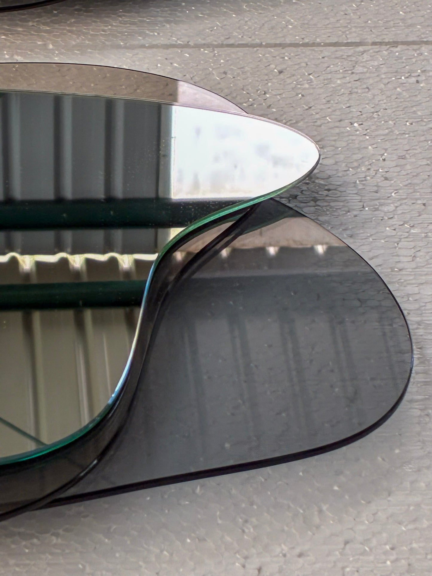 Detalle del borde pulido al agua del espejo Tríada, mostrando la unión técnica de sus tres capas de cristal.